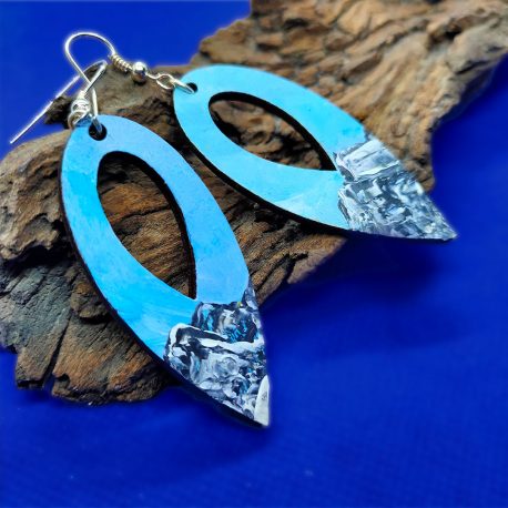 Hand painted earrings with snowy mountains close up.